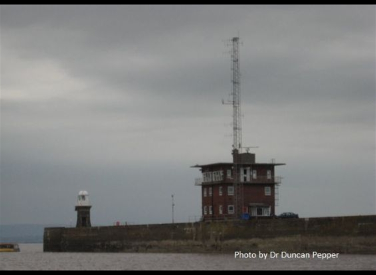 Avonmouth Pierhed with little yellow boat leaving/entering the channel close to the wall