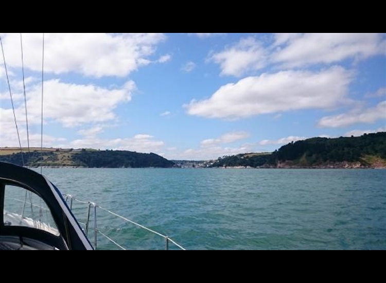 Closer approach from E.  Castle Ledge starboard channel buoy is initially visible at waterline with grey rocks becoming clearer.