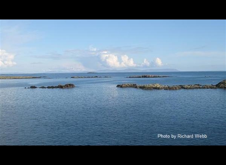 Skerries on the starboard side of the channel into the marina - Mull of Kintyre in the distance